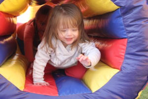 Young girl playing on inflatable bouncy house.