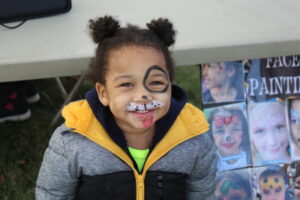 Young boy with Dalmatian face paint.
